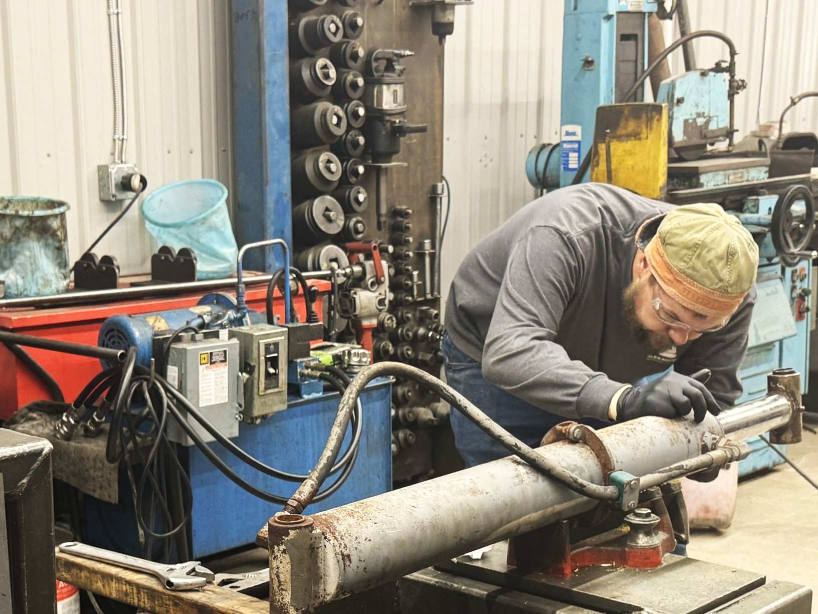Technician marking hydraulic cylinder for repair